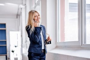 Digitalisierung Mittelstand - Setzen Sie auf Cloud Telefonie Portrait of smiling businesswoman on cell phone in office
